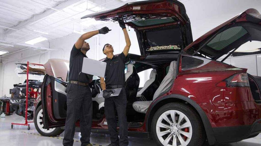 Two-men-working-on-Tesla-Model-X-Doors-Windows-Suspension-Control-Arms-iPAC-Automotive-Ontario-CA